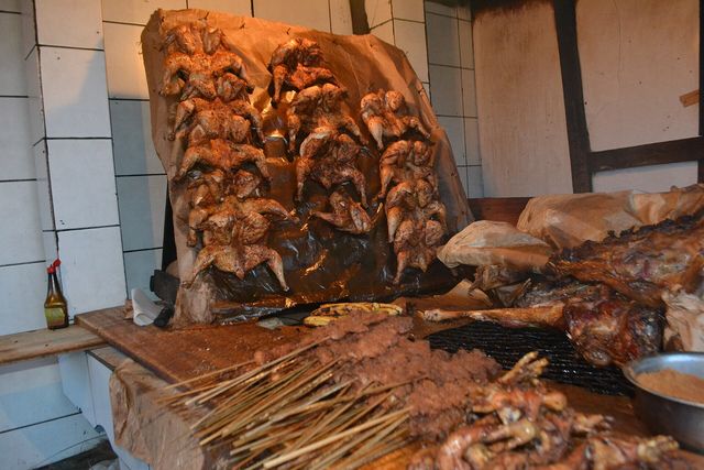 Des poulets braisés et des brochettes alignés sur un comptoir à Douala