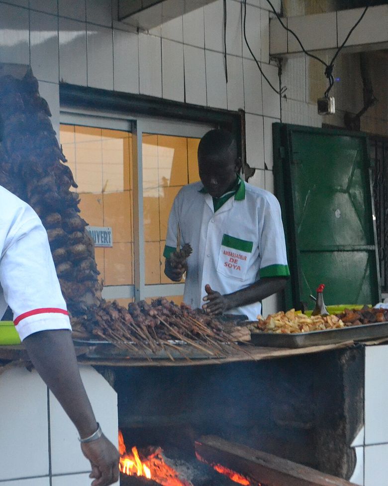 Un cuisinier prépare des brochettes de bœuf et de poulet au barbecue