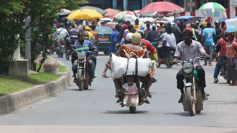 Des motos-taxis circulant dans une rue animée de Douala